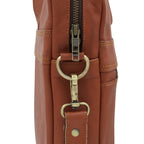 Brown leather laptop bag with brass zipper and handle on a white background