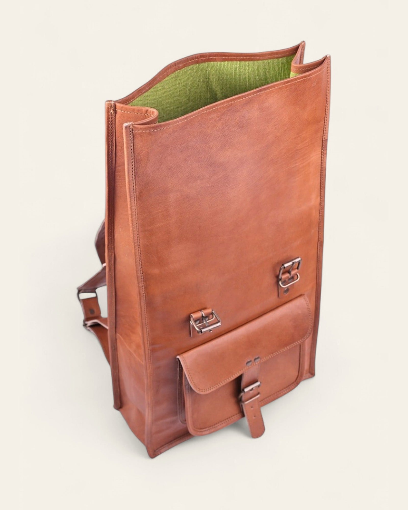 The Sariska Backpack — opened fold-over top showing the green canvas interior
