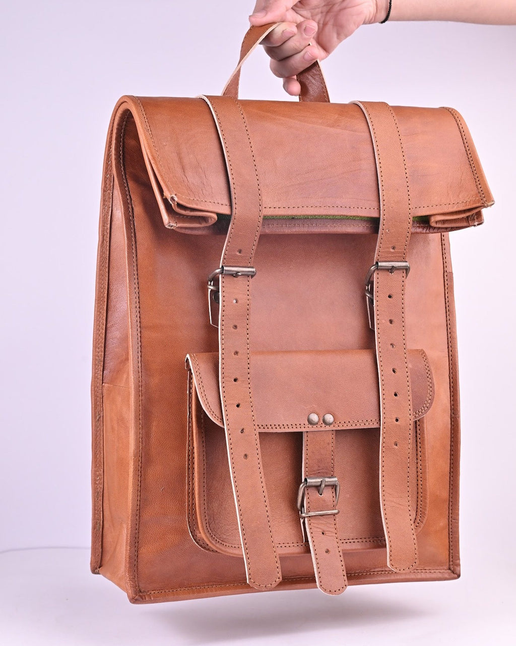 The Sariska Backpack held by its top handle — true 20 in scale