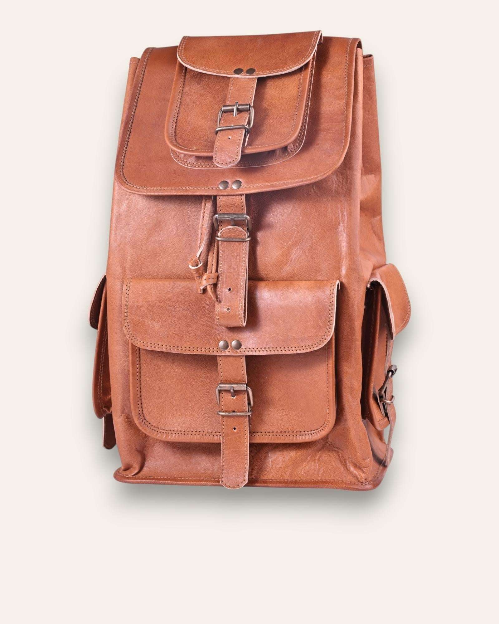 The Aravalli Backpack, a handcrafted tan goat leather rucksack featuring a buckled top flap and three exterior pockets by Jeengar.