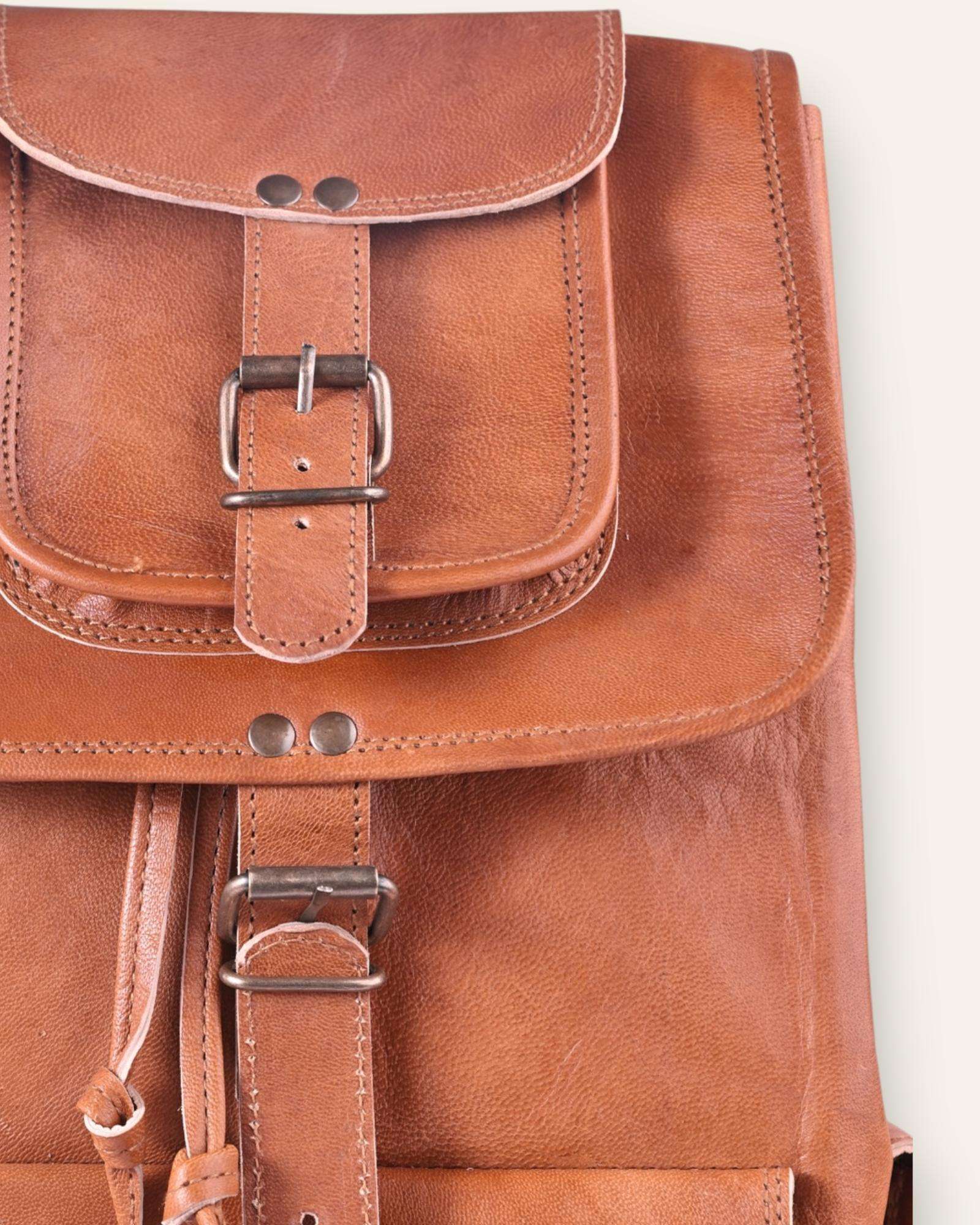 The Aravalli Backpack, a handcrafted tan goat leather rucksack featuring a buckled top flap and three exterior pockets by Jeengar.