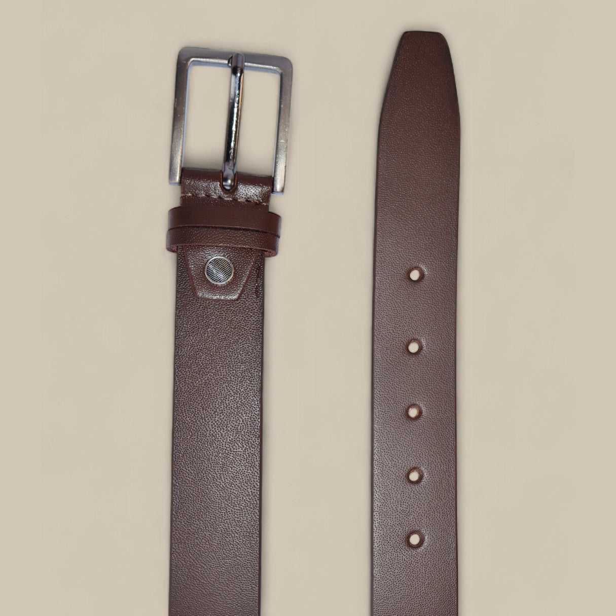 Brown leather belt with silver buckle on a beige background