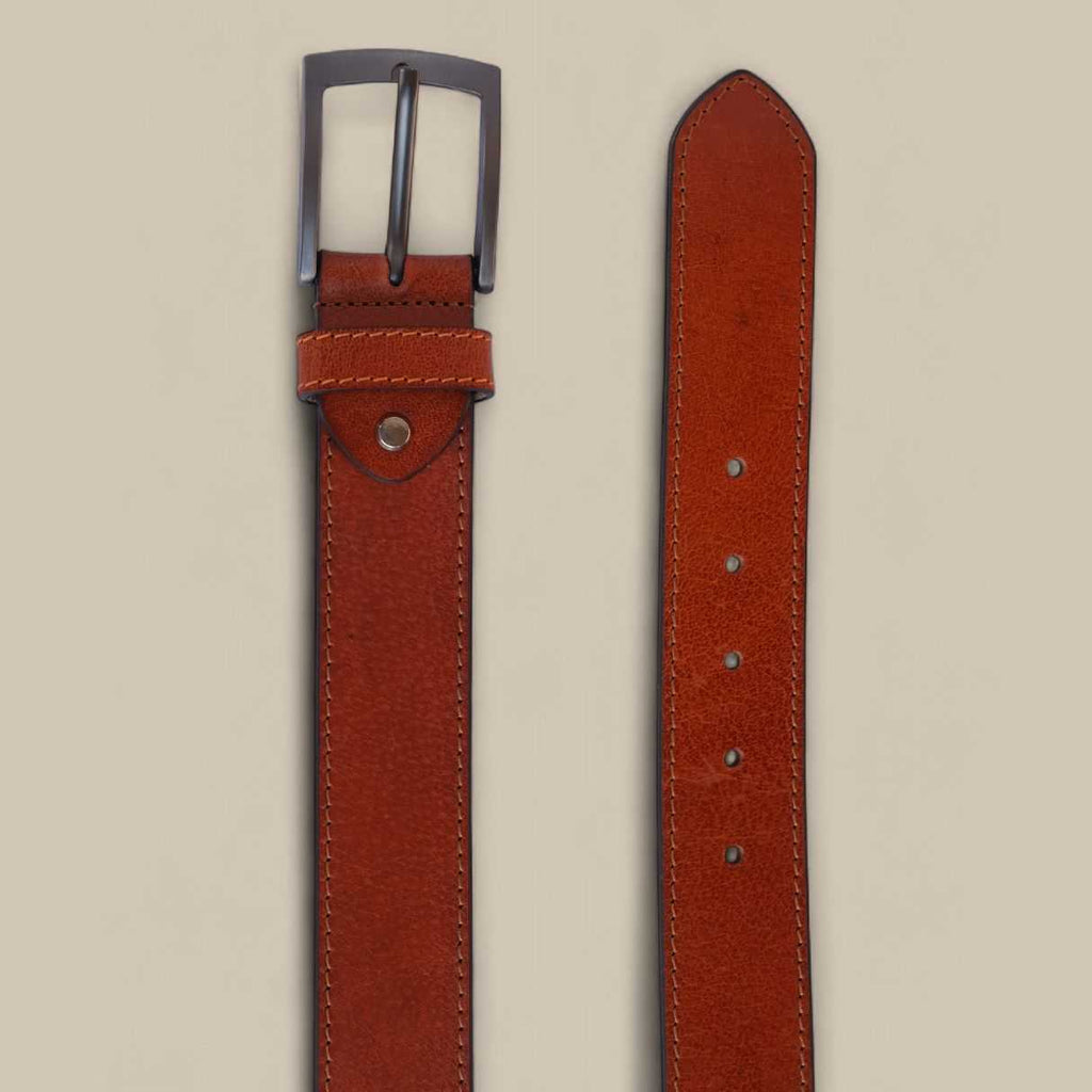Brown leather belt with a silver buckle on a beige background