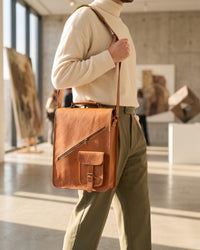 The Bundi Crossbody Bag, a tall handcrafted tan goat leather bag featuring a diagonal zipper