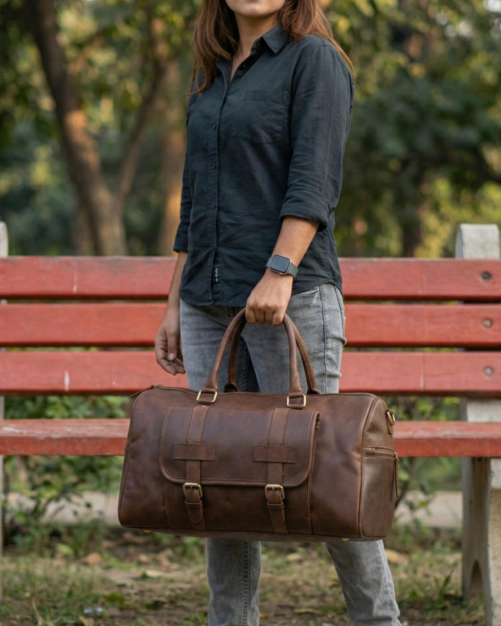 A 25 year old girl is holding a real leather duffel bag made by Jeengar artisans