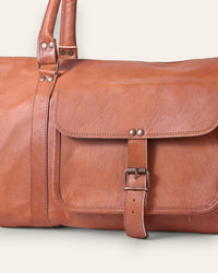 A triangle shapped duffel bag in real tan leather color