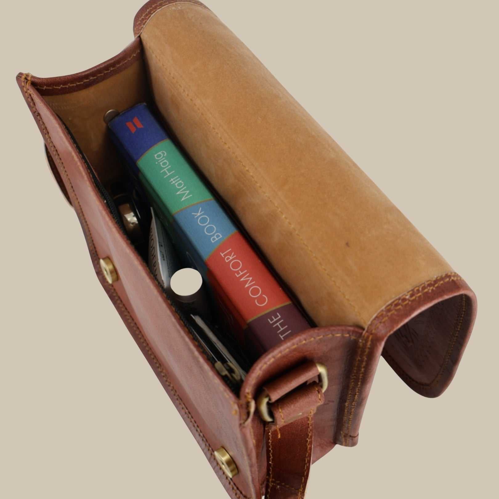 Brown leather case with colorful book inside on a beige background
