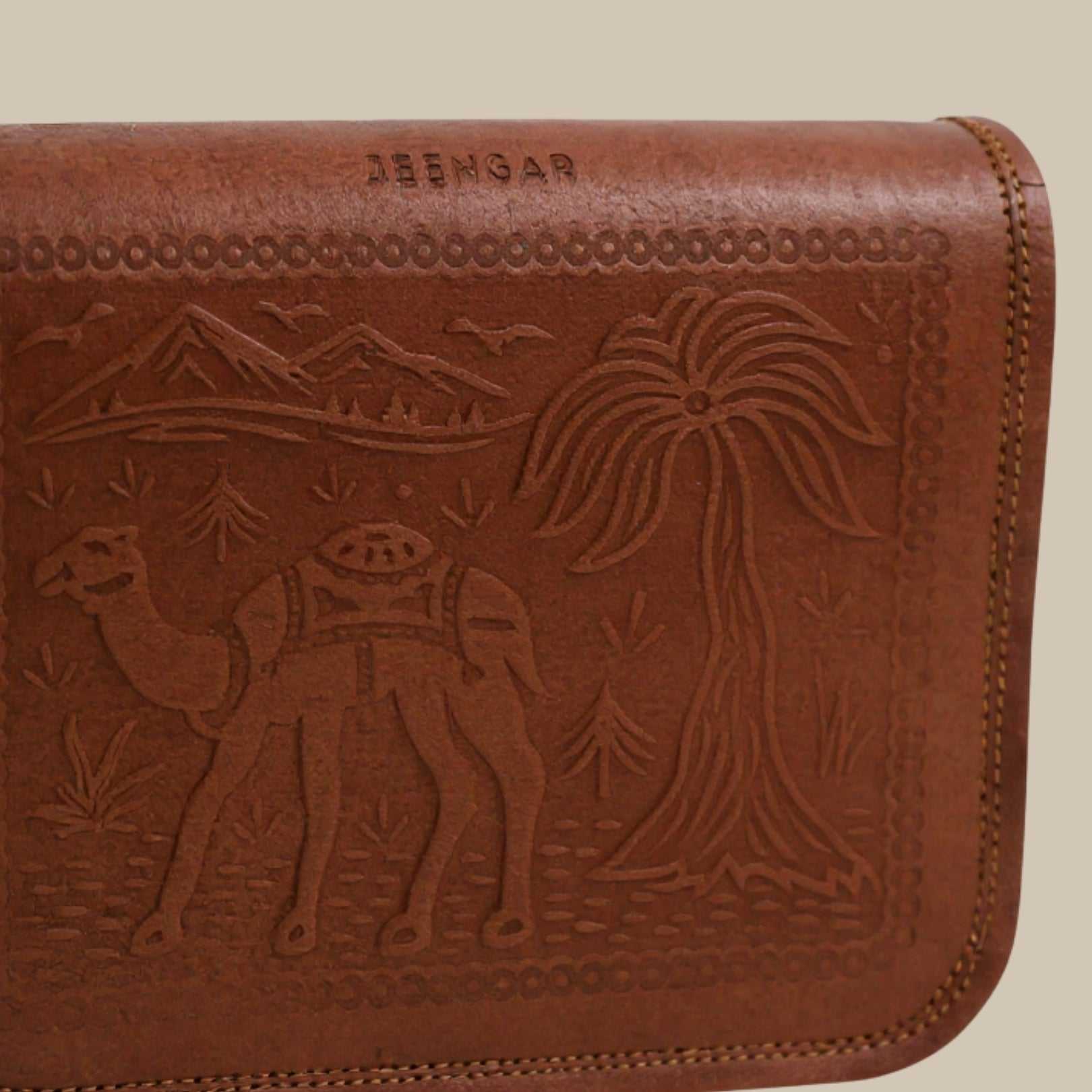 Brown leather wallet with embossed design of a camel and palm tree, brand 'JEENGAR' visible.