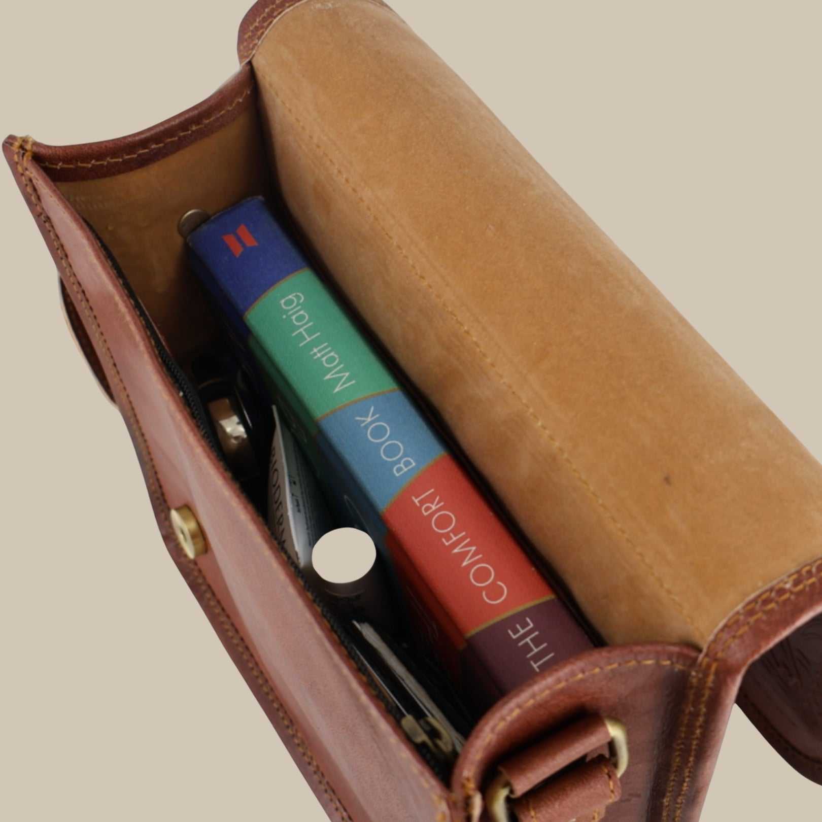 A cherry Red leather case with colorful booklets inside on a beige background
