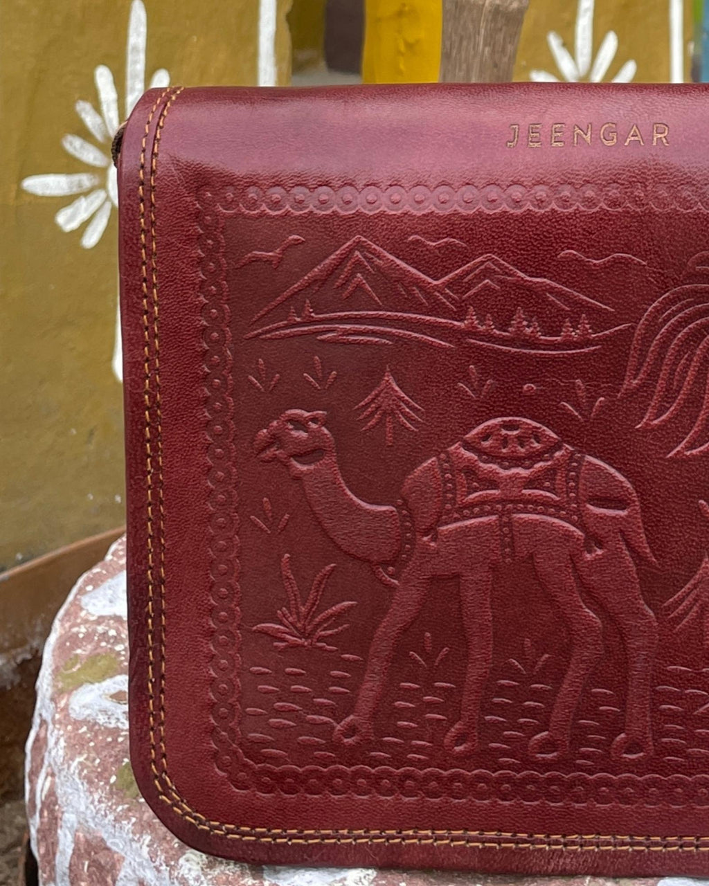 a cherry color real leather sling bag. Handmade in rajasthan