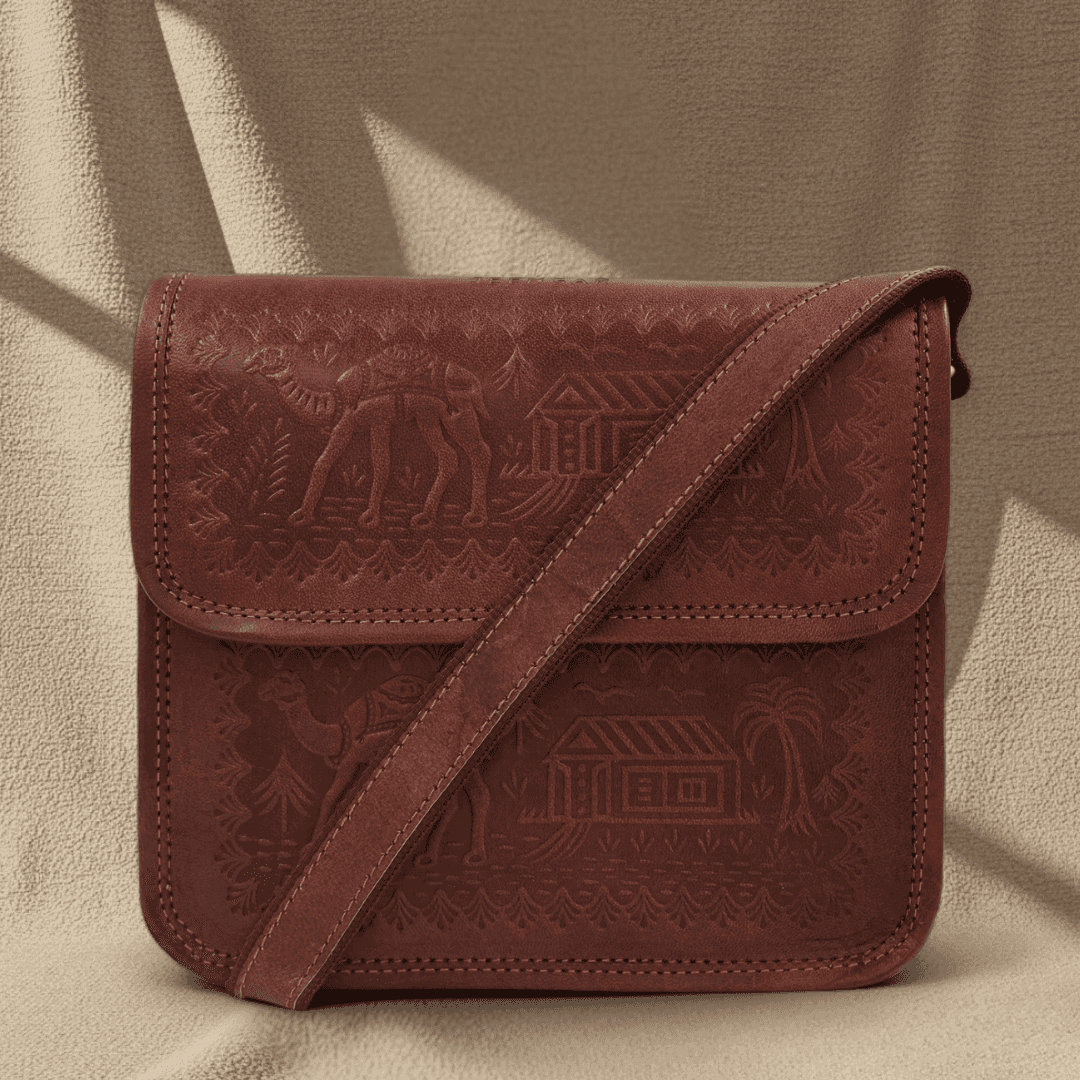 A cherry leather bag with embossed designs on a beige background