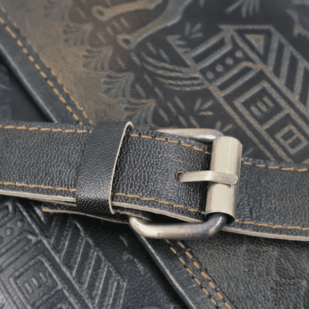 Close-up of a leather strap with buckle on a textured surface