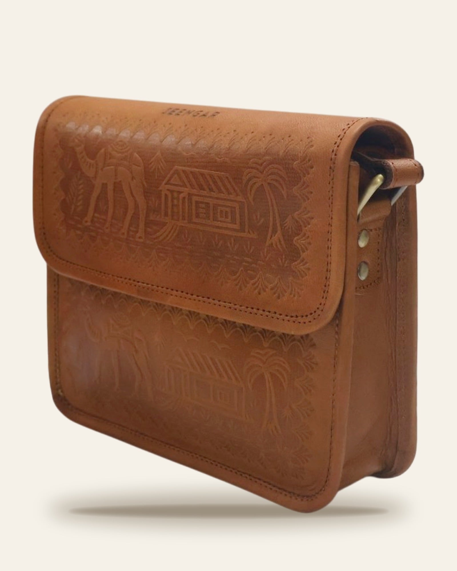 The Pushkar Sling in Tan — three-quarter view of the embossed flap