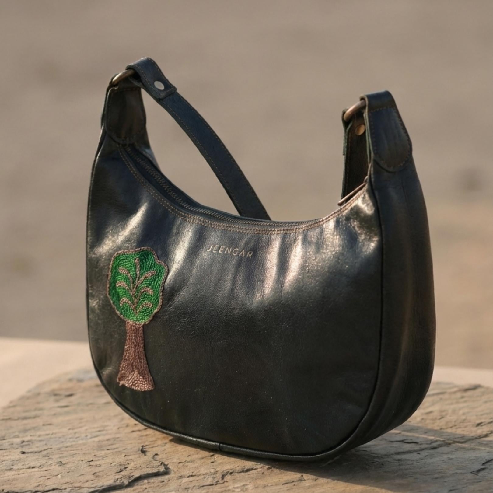 The Padmini Shoulder Bag in dark olive top-grain leather with the Tree of Life embroidery.