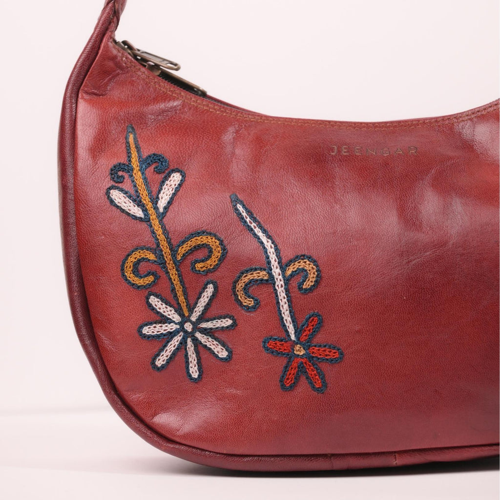 Close-up of the unique folk-art embroidery on the Mira leather shoulder bag.