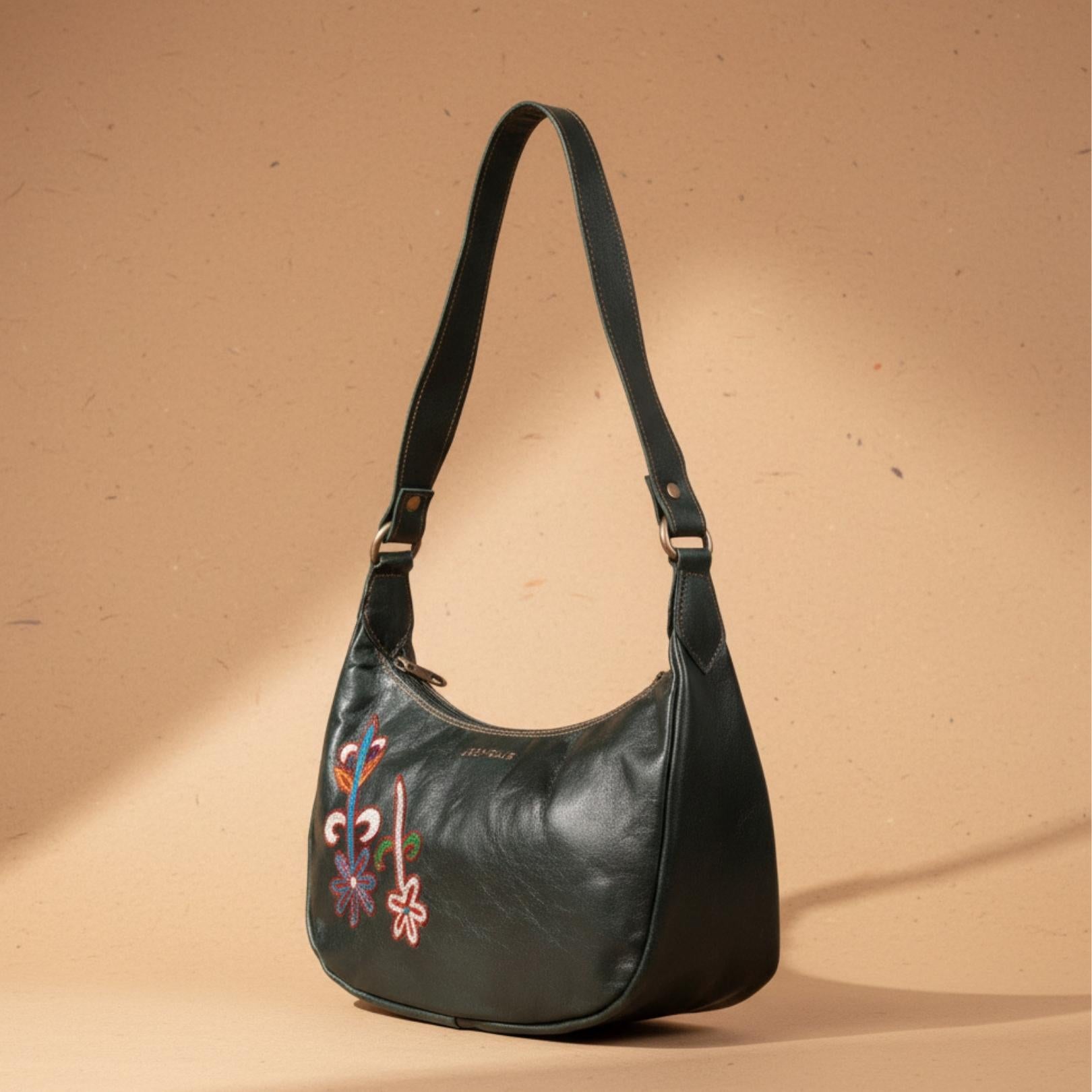 The Mira Shoulder Bag in dark olive top-grain leather, featuring colorful abstract embroidery.
