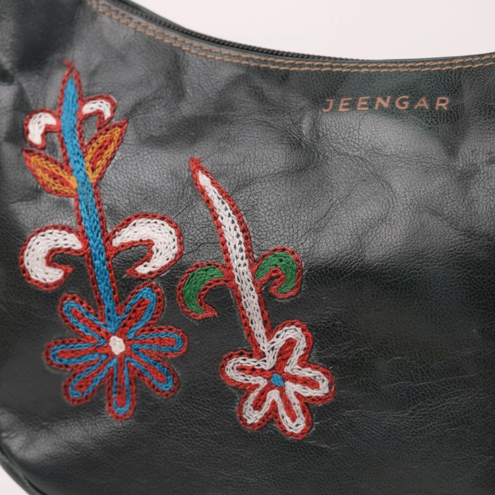 Close-up of the unique folk-art embroidery on the Mira leather shoulder bag.