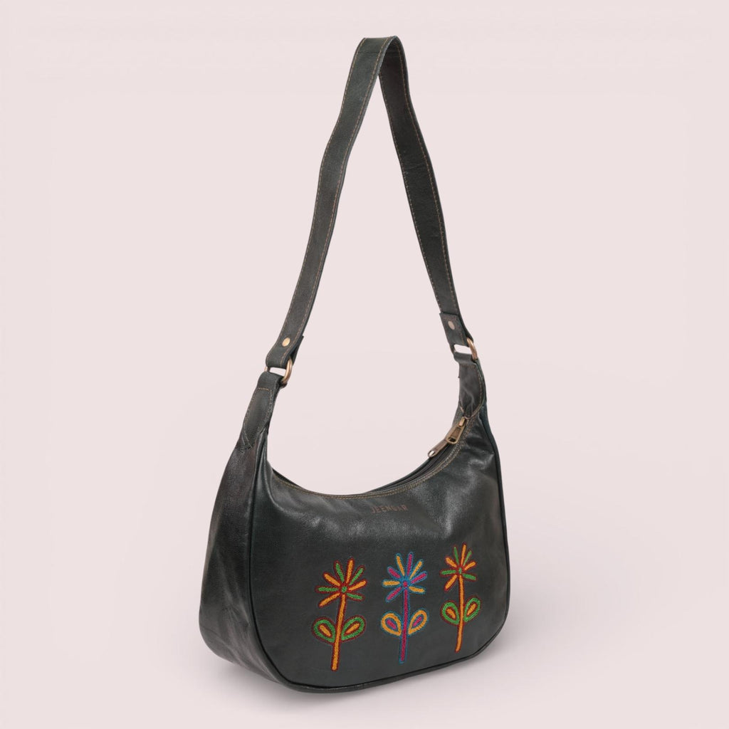 The Sanyogita Shoulder Bag in dark olive top-grain leather, with a trio of hand-embroidered folk-art flowers.