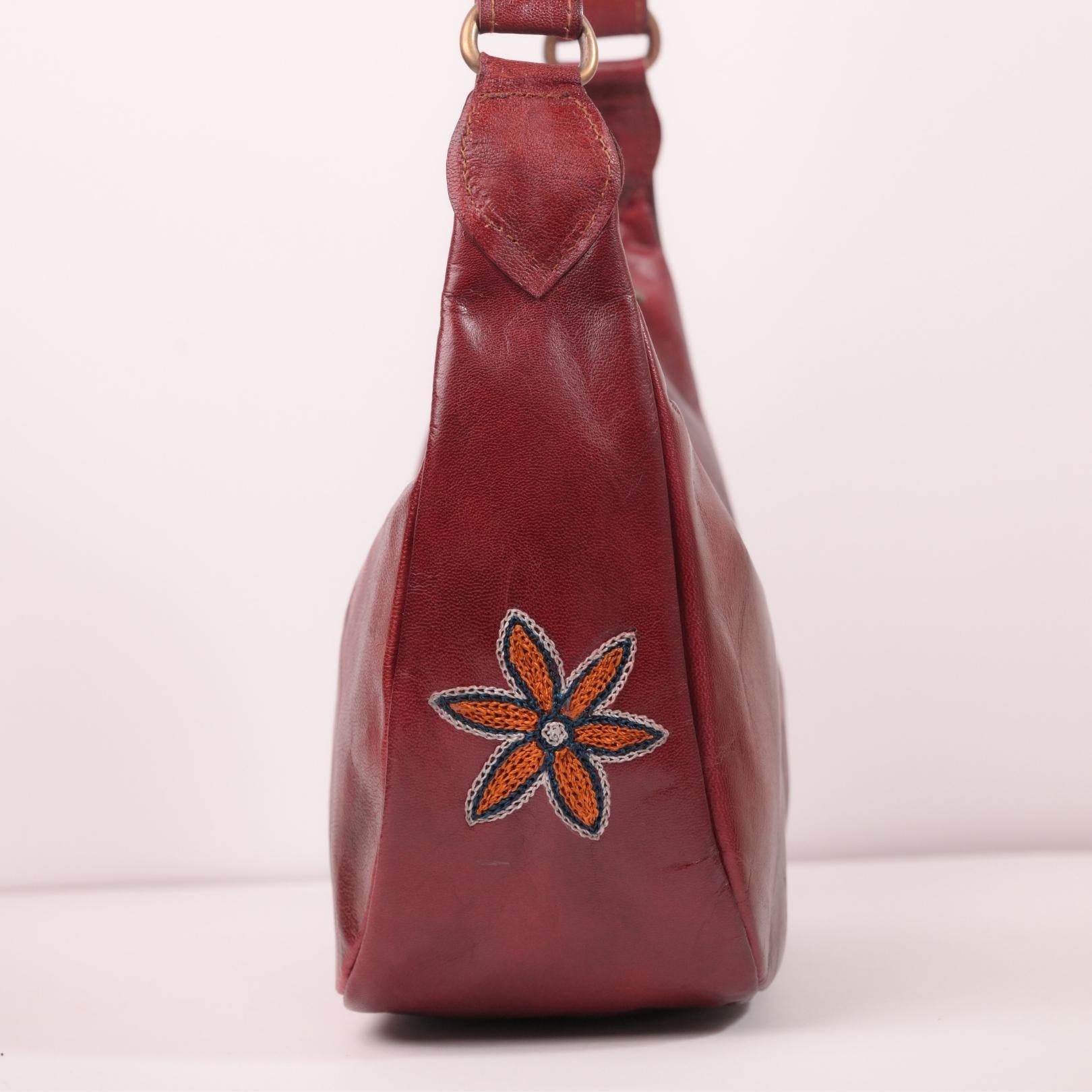 Close-up of the single embroidered flower detail on the Moomal leather shoulder bag.