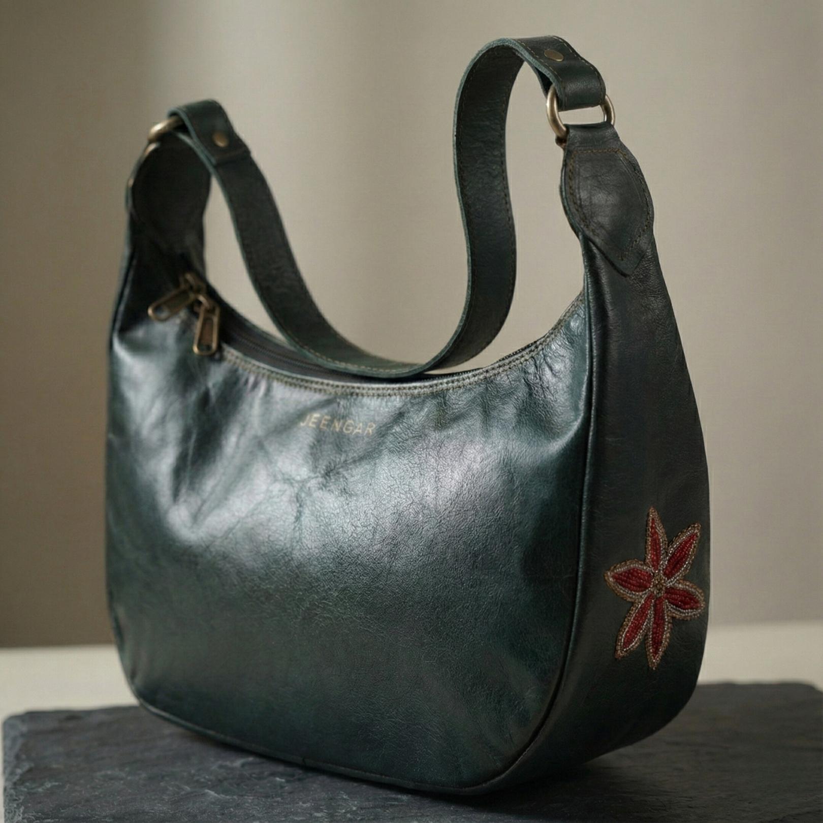 The Moomal Shoulder Bag in dark olive top-grain leather, featuring a single floral embroidery.