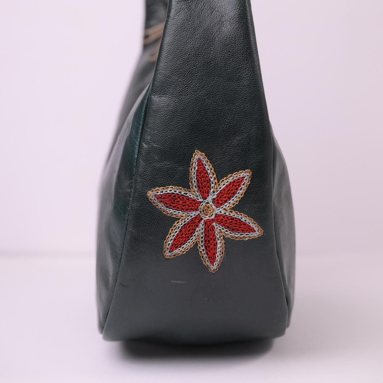 Close-up of the single embroidered flower detail on the Moomal leather shoulder bag.