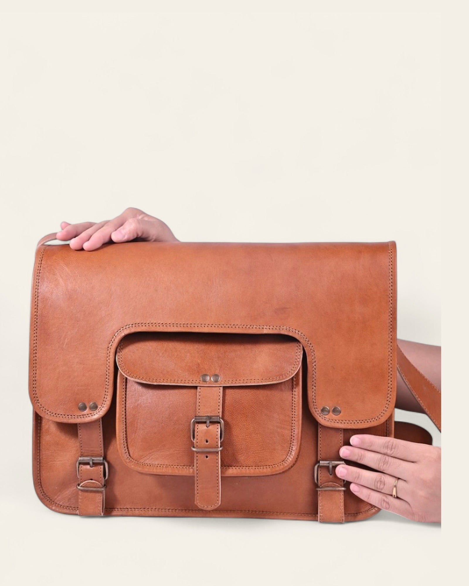 The Kota Laptop Bag held in hand to show its scale