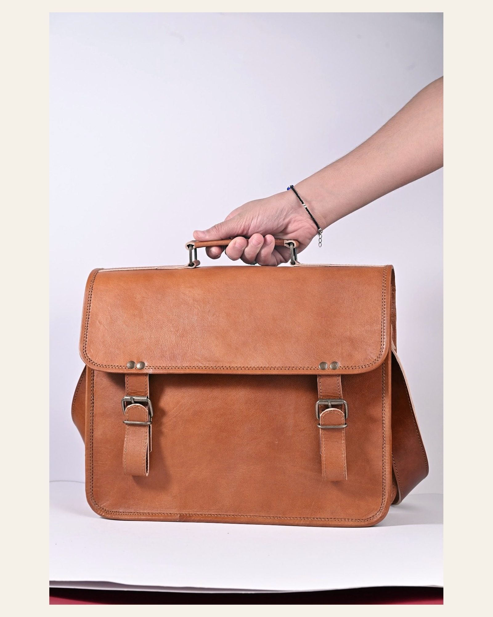 The Ajmer Laptop Bag carried by its top handle to show scale