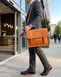 The Umaid Briefcase, a 15-inch handcrafted tan goat leather laptop bag with a no top handle and dual brass clasps by Jeengar.