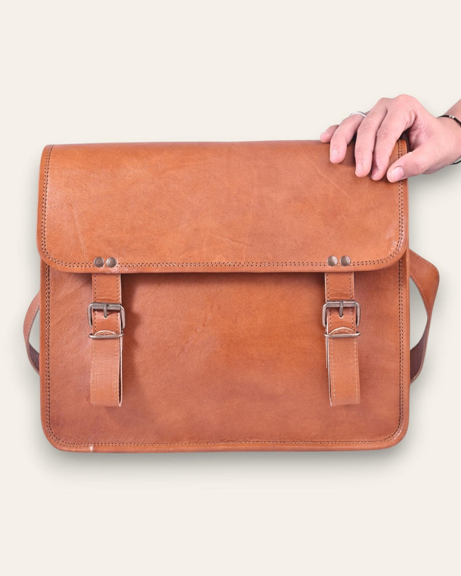 The Umaid Briefcase, a 15-inch handcrafted tan goat leather laptop bag with a no top handle and dual brass clasps by Jeengar.