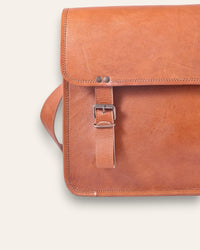 The Umaid Briefcase, a 15-inch handcrafted tan goat leather laptop bag with a no top handle and dual brass clasps by Jeengar.