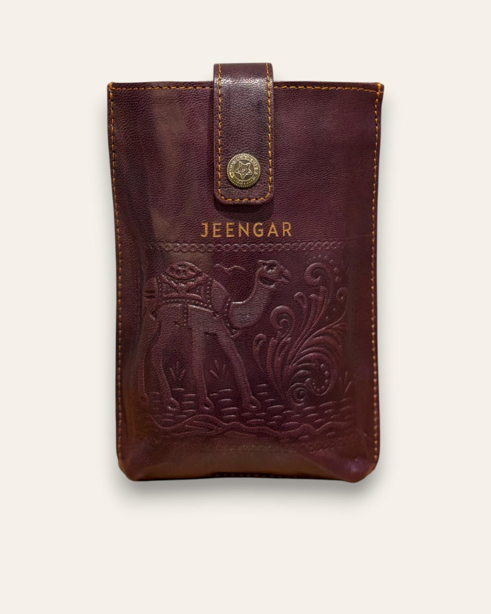 The Osian Mobile Sling, a handcrafted cherry red leather phone bag featuring a hand-embossed camel motif by Jeengar.