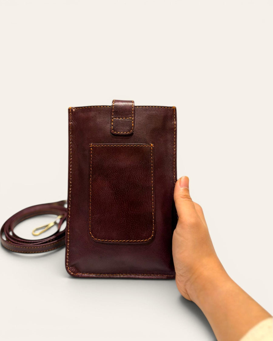 The Osian Mobile Sling, a handcrafted cherry red leather phone bag featuring a hand-embossed camel motif by Jeengar.