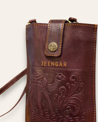 The Osian Mobile Sling, a handcrafted cherry red leather phone bag featuring a hand-embossed camel motif by Jeengar.