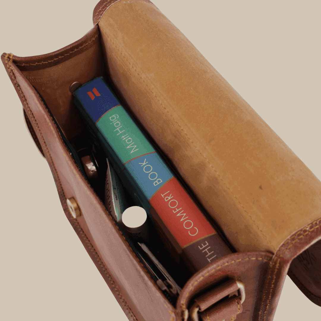 Brown leather case with colorful book inside on a beige background