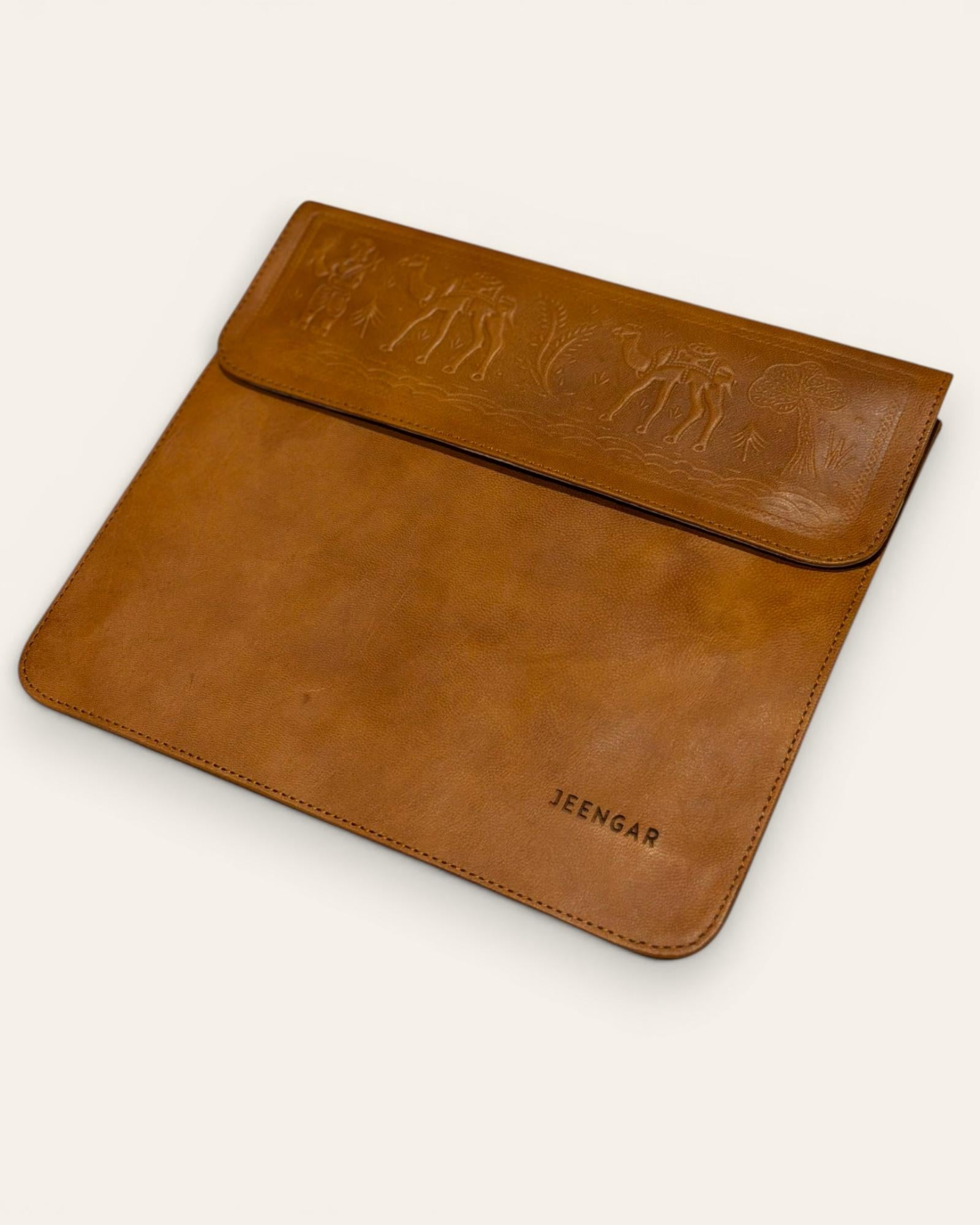 The Barmer Tech Sleeve, a handcrafted tan full-grain leather iPad and MacBook sleeve featuring a hand-embossed desert camel motif by Jeengar.