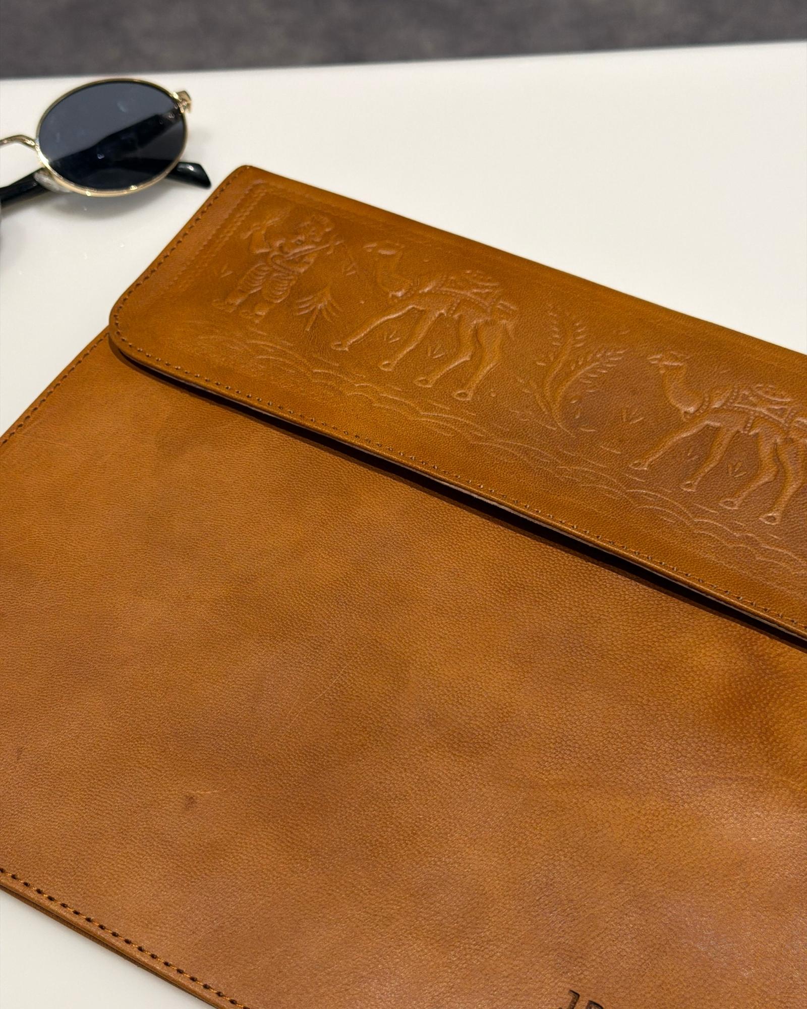The Barmer Tech Sleeve, a handcrafted tan full-grain leather iPad and MacBook sleeve featuring a hand-embossed desert camel motif by Jeengar.